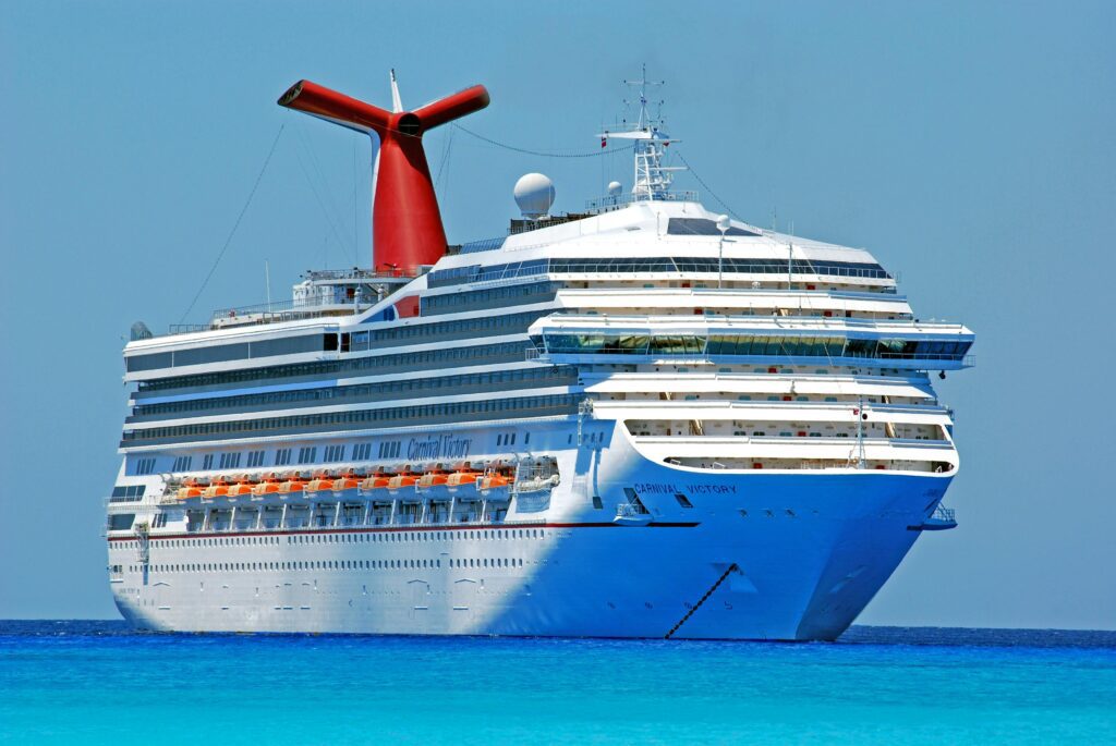 ferry-boat-ferry-ship-boat-69122-69122 A large cruise ship gliding through clear blue ocean waters on a sunny day.